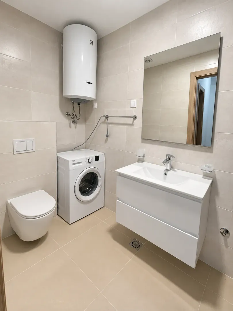 Modern bathroom equipped with a sink, toilet, and washing machine.