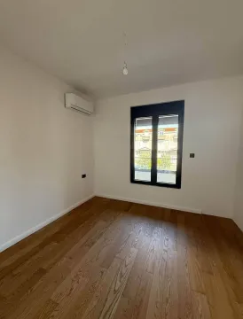 Prazna soba sa parketom, bijelim zidovima i klima uređajem. - image 6