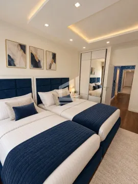 Modern bedroom with two beds, built-in wardrobe, and a dropped ceiling with lighting. - image 8
