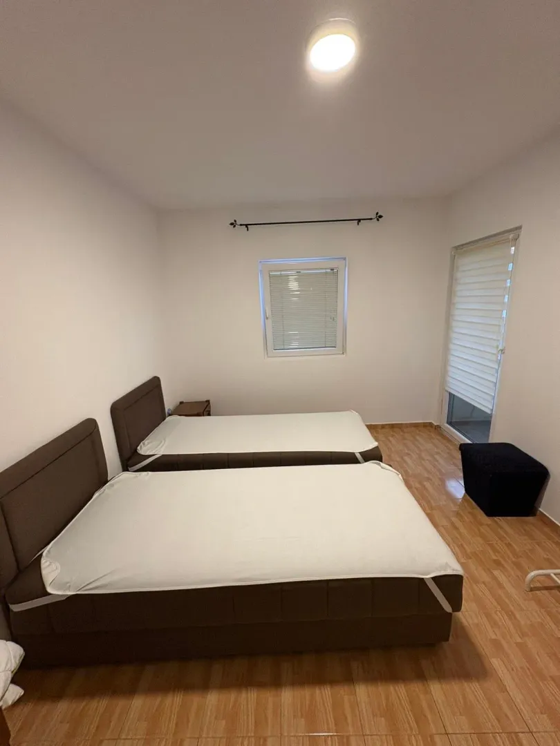 Bedroom with two beds and laminate flooring.