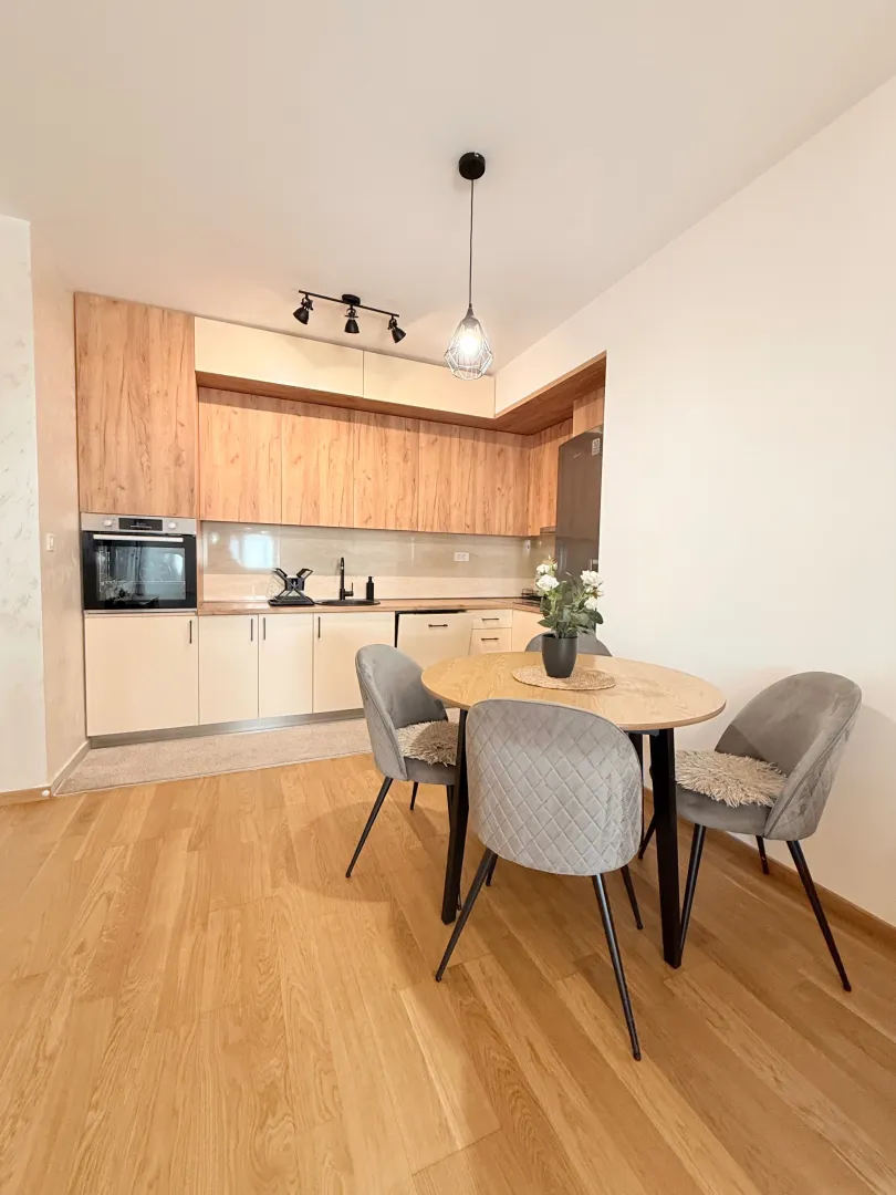 Modern kitchen with dining area and wooden elements.