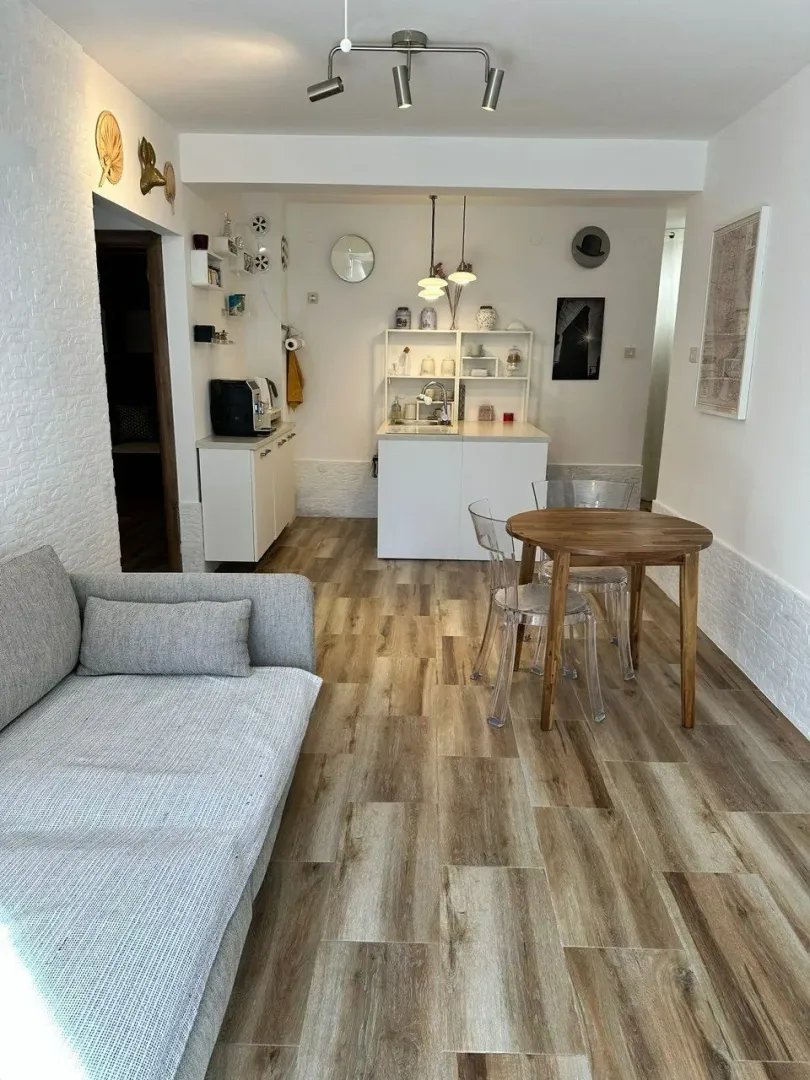 Living room with a dining area and kitchen in bright tones.