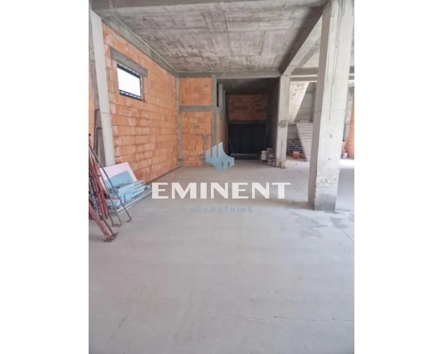 Unfinished bare space under construction with brick walls and concrete pillars.