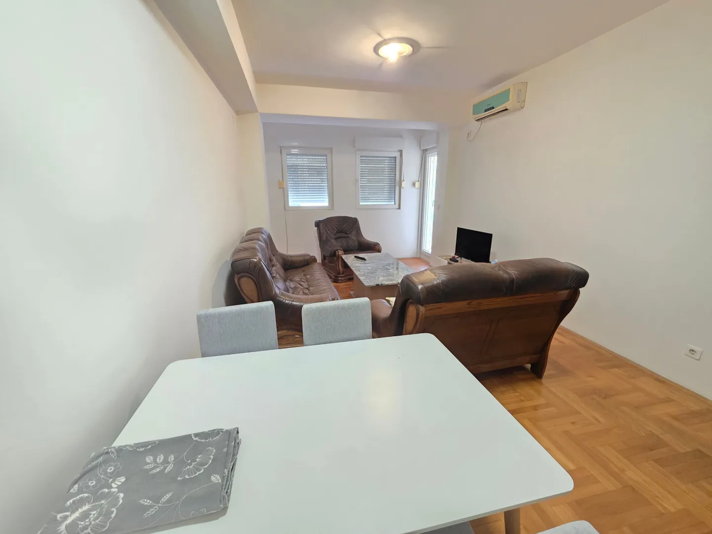 Living room with a sofa set and a dining table in the foreground.