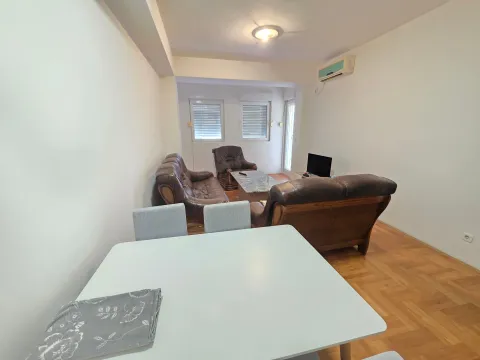 Living room with a sofa set and a dining table in the foreground. - image 2