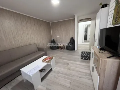 Dnevna soba sa garniturom za sedenje, televizorom i stočićem. - image 4