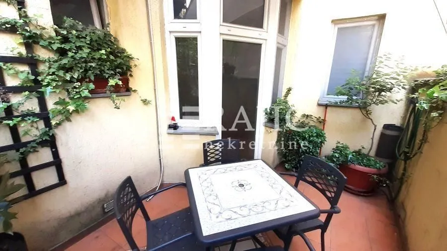 Small terrace with outdoor seating and greenery.