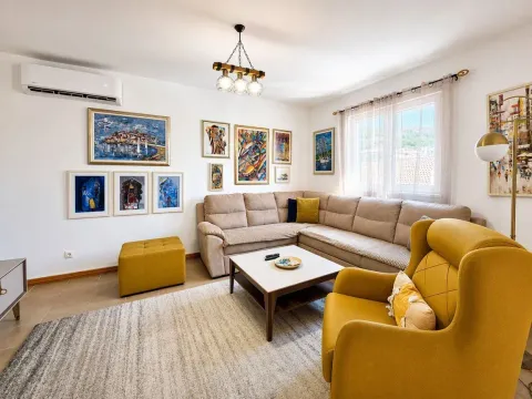 Dnevna soba sa garniturom, foteljom i umjetničkim slikama na zidu. - image 14
