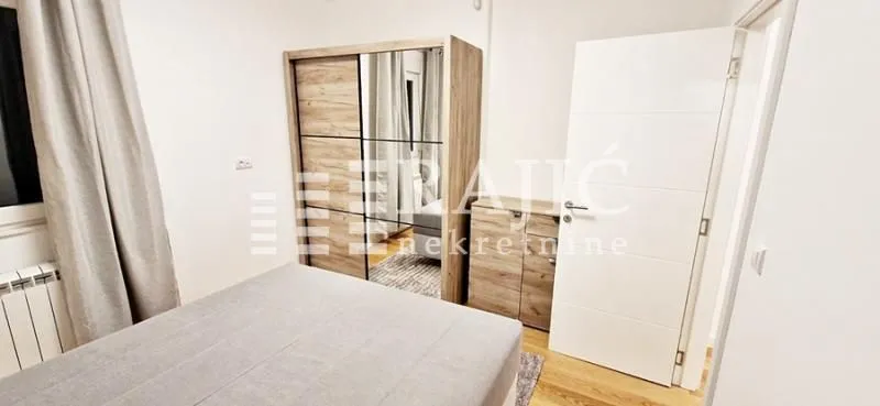 Furnished bedroom with a double bed and a wardrobe.