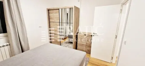 Furnished bedroom with a double bed and a wardrobe. - image 7