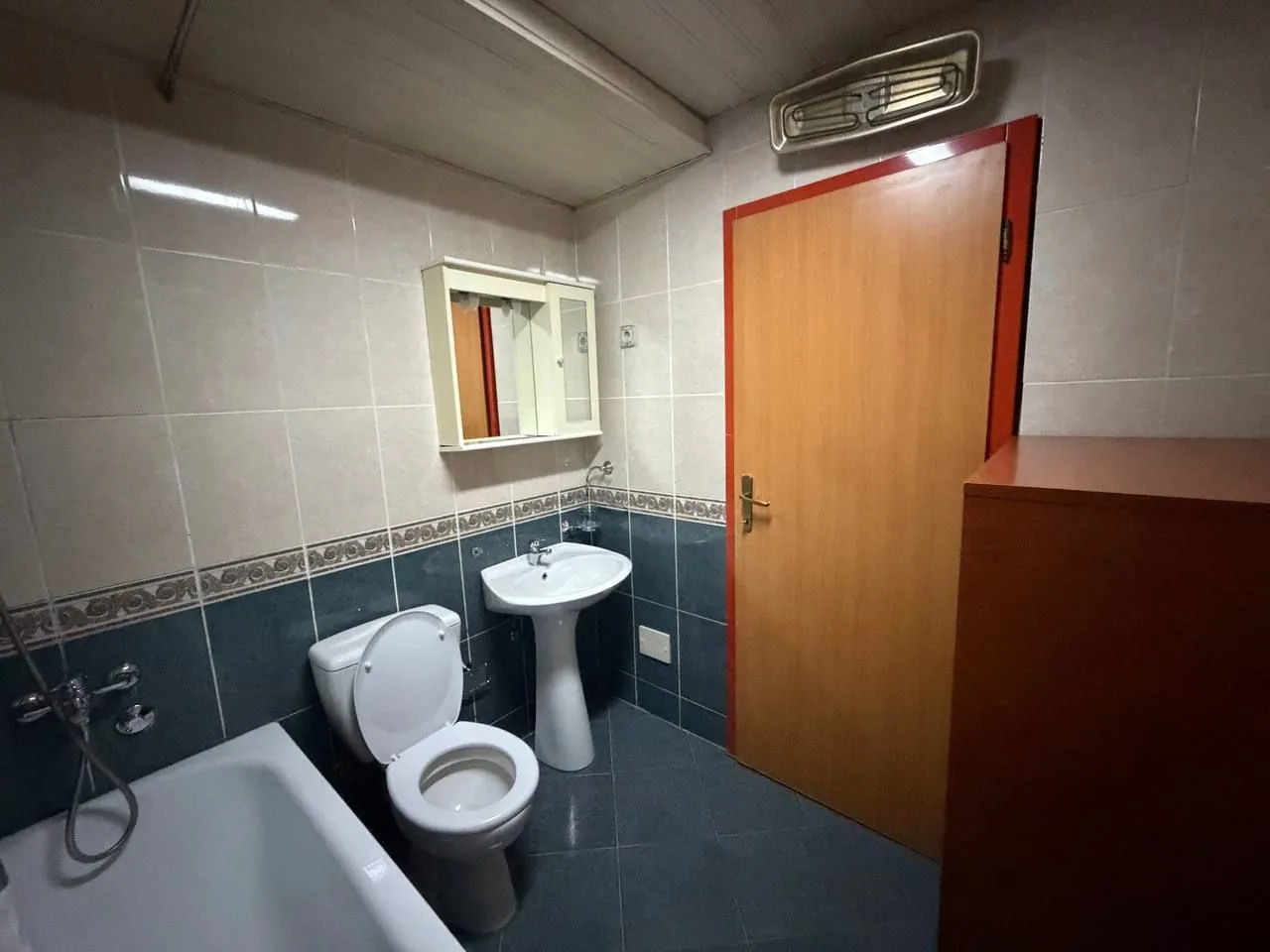 Smaller bathroom with a bathtub, washbasin, and toilet.