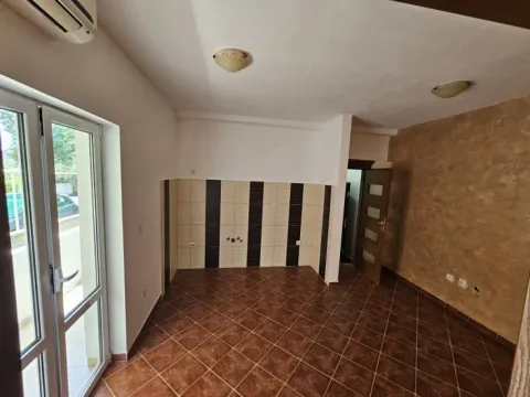 Prazna kuhinja sa keramičkim pločicama i balkonskim vratima. - image 2