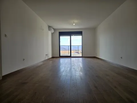 Empty living room with wooden flooring and balcony access. - image 2