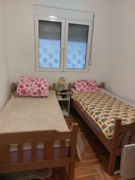 Bedroom with two wooden beds and a window. - image 2