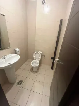 Small bathroom with a sink and toilet tiled with light-colored tiles. - image 8