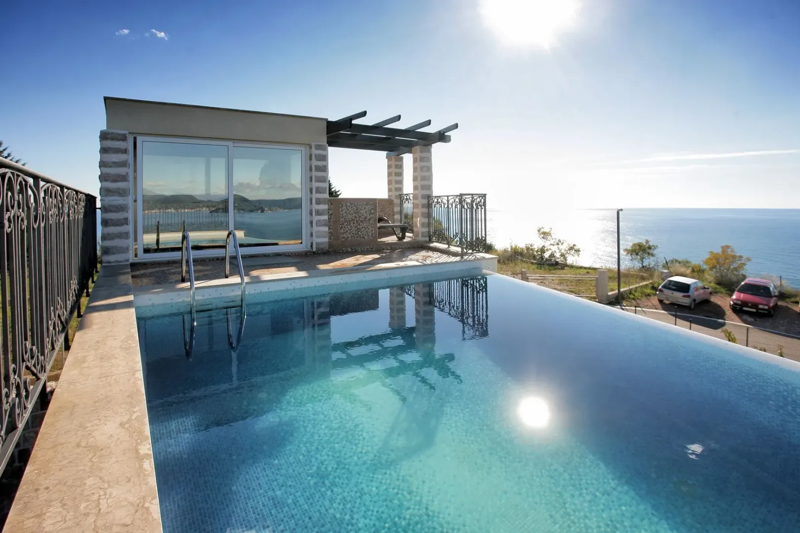 Outdoor swimming pool with a sea view and a covered terrace.