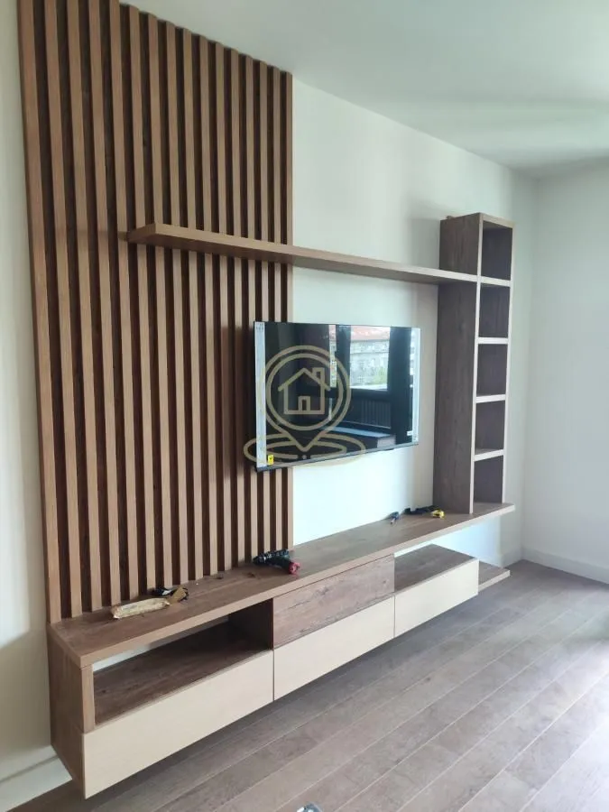 Living room featuring a wooden wall panel and a television.