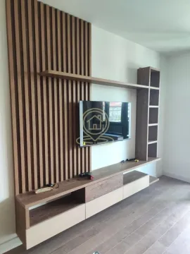 Living room featuring a wooden wall panel and a television. - image 4