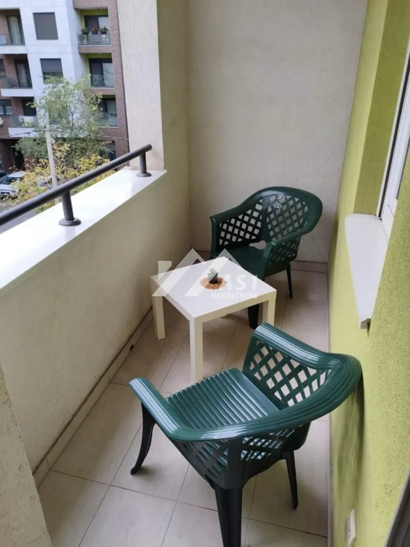 Manji namešteni balkon sa stolom i dve stolice.