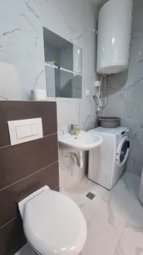 Moderno opremljeno kupatilo sa sanitarijama i veš mašinom. - image 7