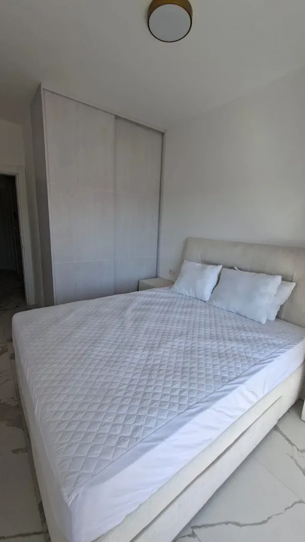 Bright bedroom with a double bed and a built-in wardrobe.