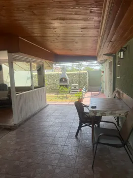 Natkrivena terasa sa stolom, stolicama i pogledom na dvorište sa roštiljem. - image 8