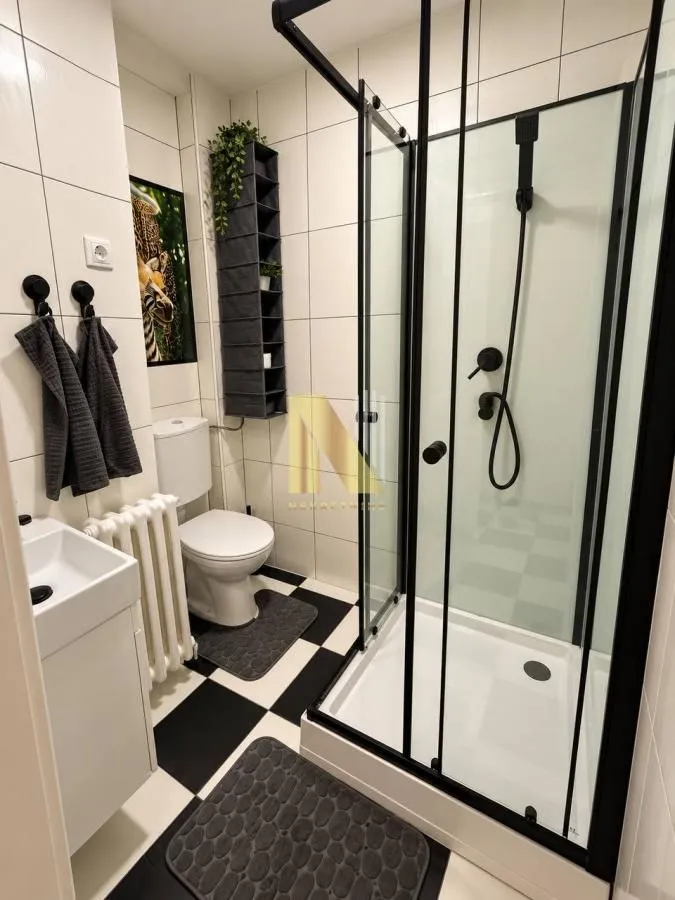 Manje kupatilo sa tuš kabinom, umivaonikom i WC šoljom.