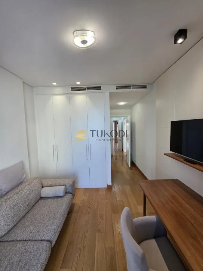 Living room with sofa, desk, built-in wardrobe and TV.