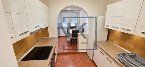 Kuhinja sa bijelim elementima i pogledom na trpezariju kroz luk. - image 4