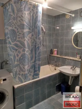 Kupatilo obloženo pločicama sa kadom, umivaonikom i veš mašinom. - image 5