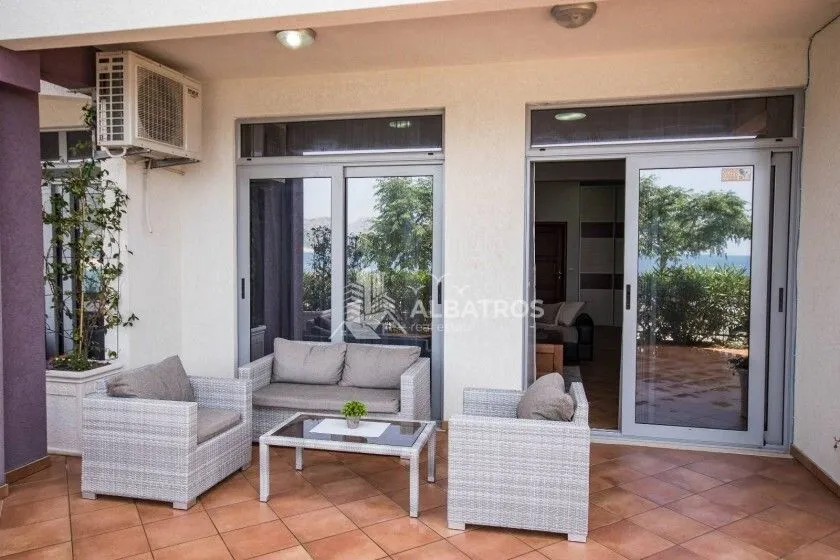 Covered terrace with seating furniture and a view of the courtyard.