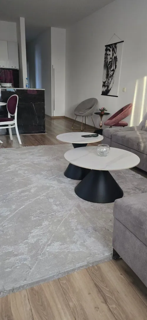 Spacious living room with a sofa and two round coffee tables.