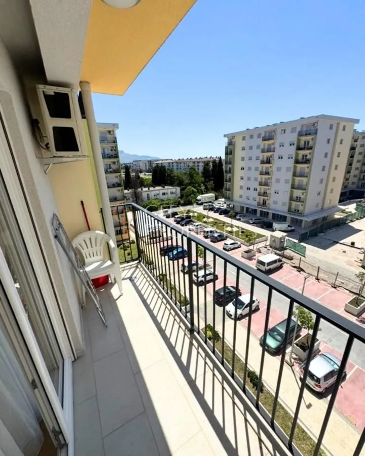 View from the balcony overlooking surrounding residential buildings and parking lot.