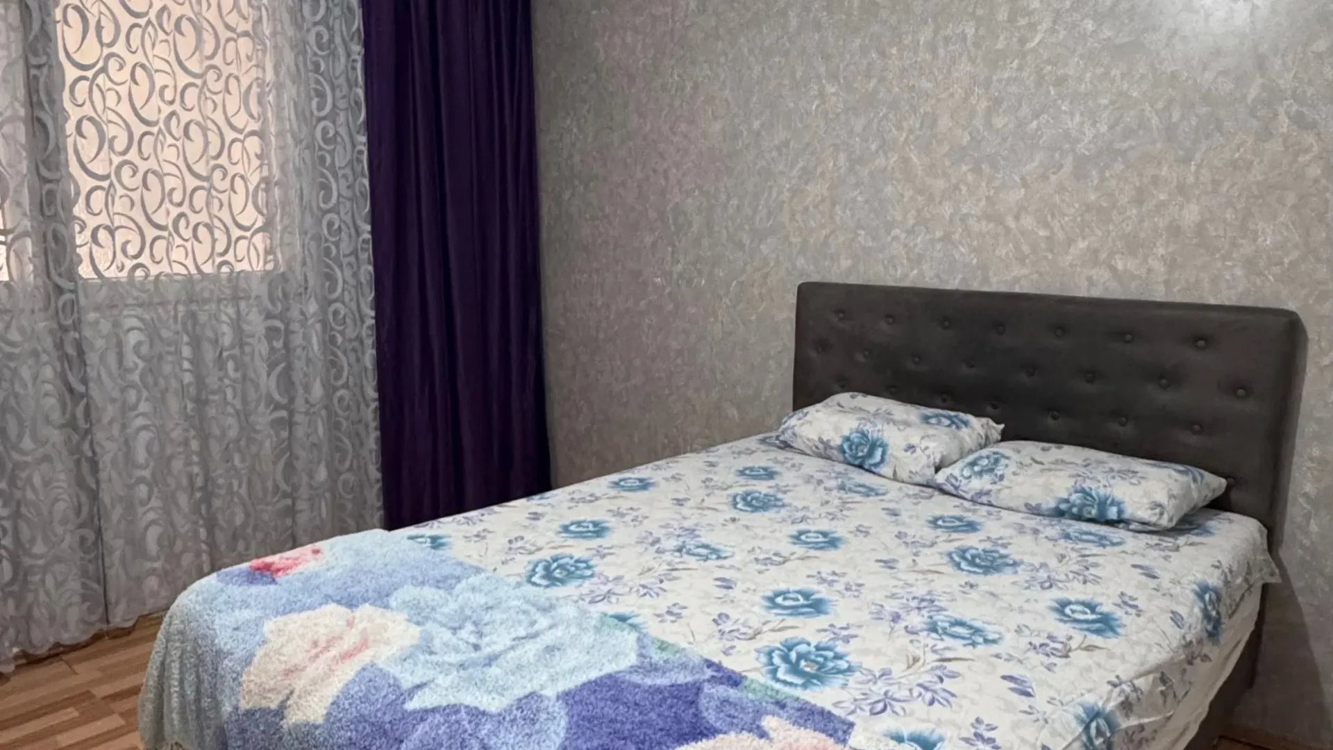 Bedroom with a double bed, window and laminate flooring.