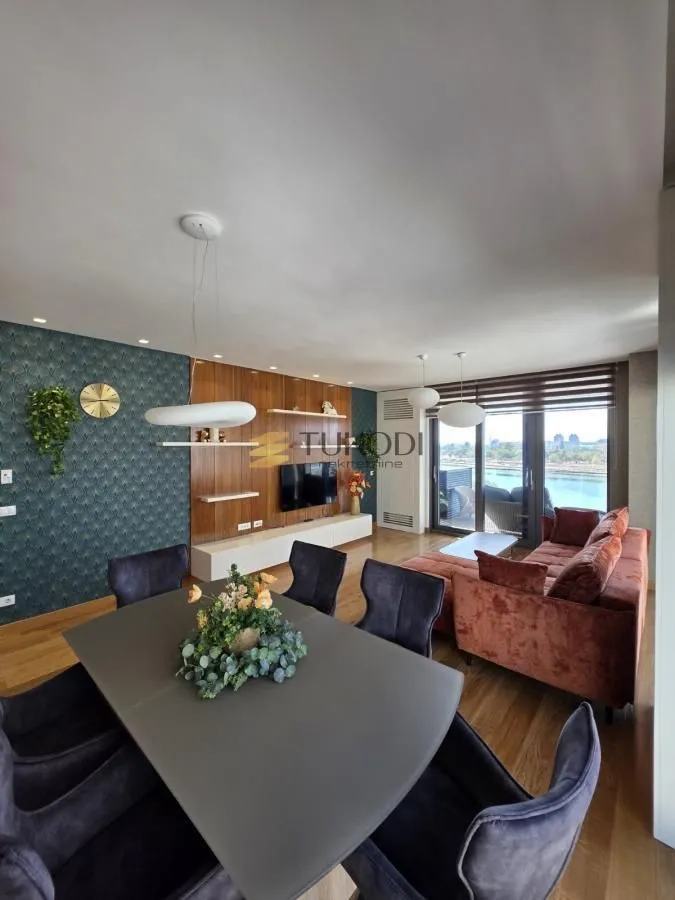 Living room with dining area and access to a terrace with a river view.