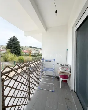 Covered balcony with a drying rack and a view of the surroundings. - image 2