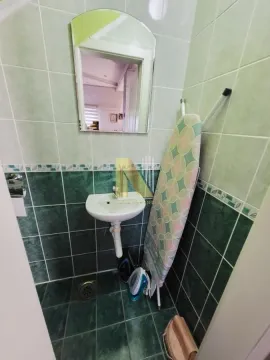 Manje kupatilo sa umivaonikom, ogledalom i zelenim pločicama. - image 25