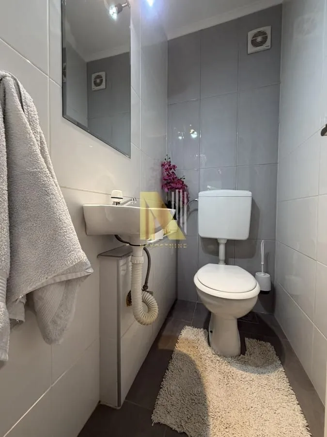 Manje kupatilo sa umivaonikom i wc šoljom.