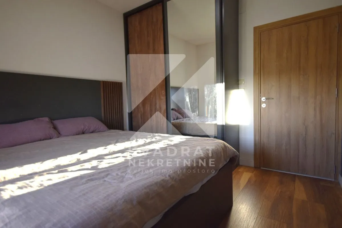 Bedroom with a double bed, mirrored wardrobe, and wooden doors.