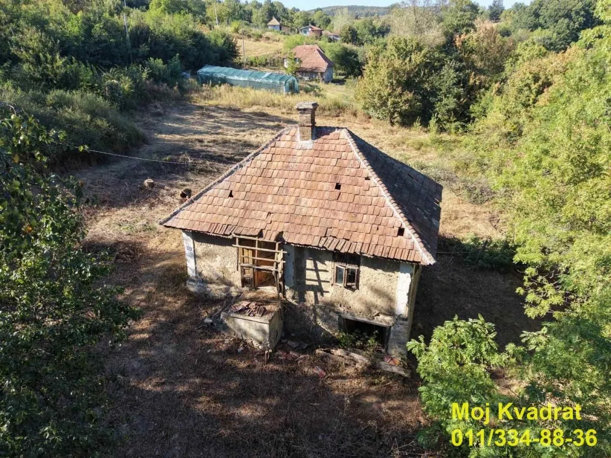 Pogled iz vazduha na stariji objekat sa placem i okolnim zelenilom.