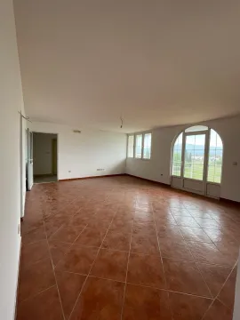 Prostrana prazna prostorija sa pločicama od terakote i velikim lučnim balkonskim vratima. - image 11