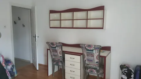 A study desk with two chairs and a wall shelf in a room. - image 9