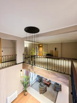 View from the gallery overlooking the living room and modern staircase with a chandelier. - image 3
