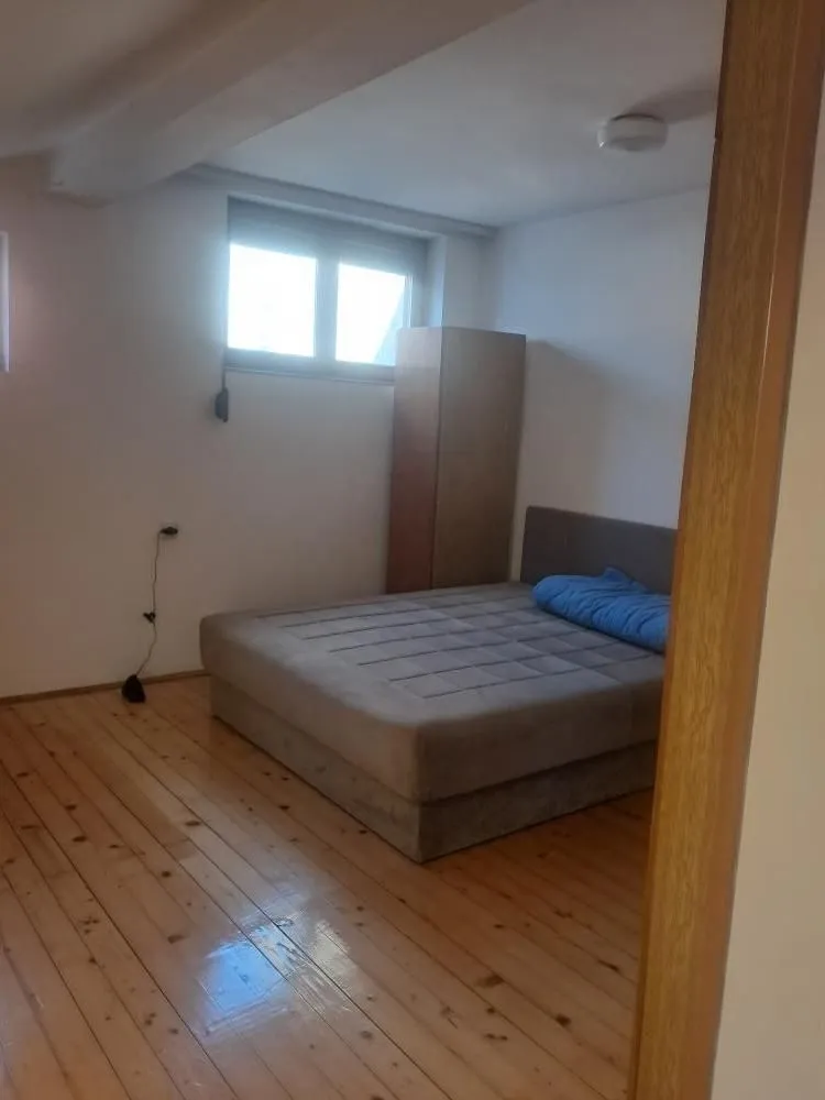 Bedroom with a double bed, wooden floor, and wardrobe.