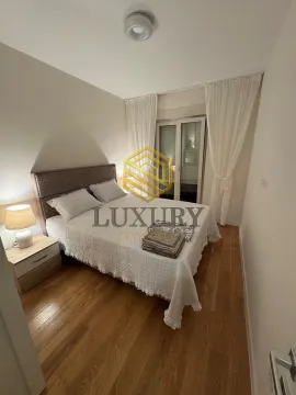 Bedroom with a double bed, nightstand, and balcony doors. - image 2