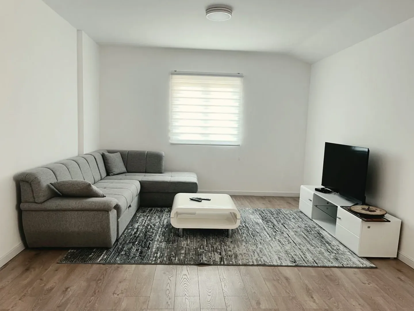 Living room with a sectional sofa, TV, and coffee table.