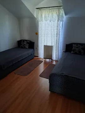 Bedroom with two single beds and wooden flooring. - image 9