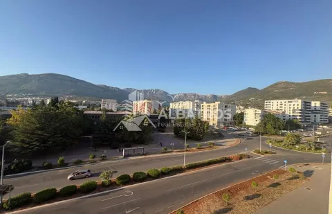 Pogled sa prozora na okolne zgrade, ulice i planine u pozadini. - image 10