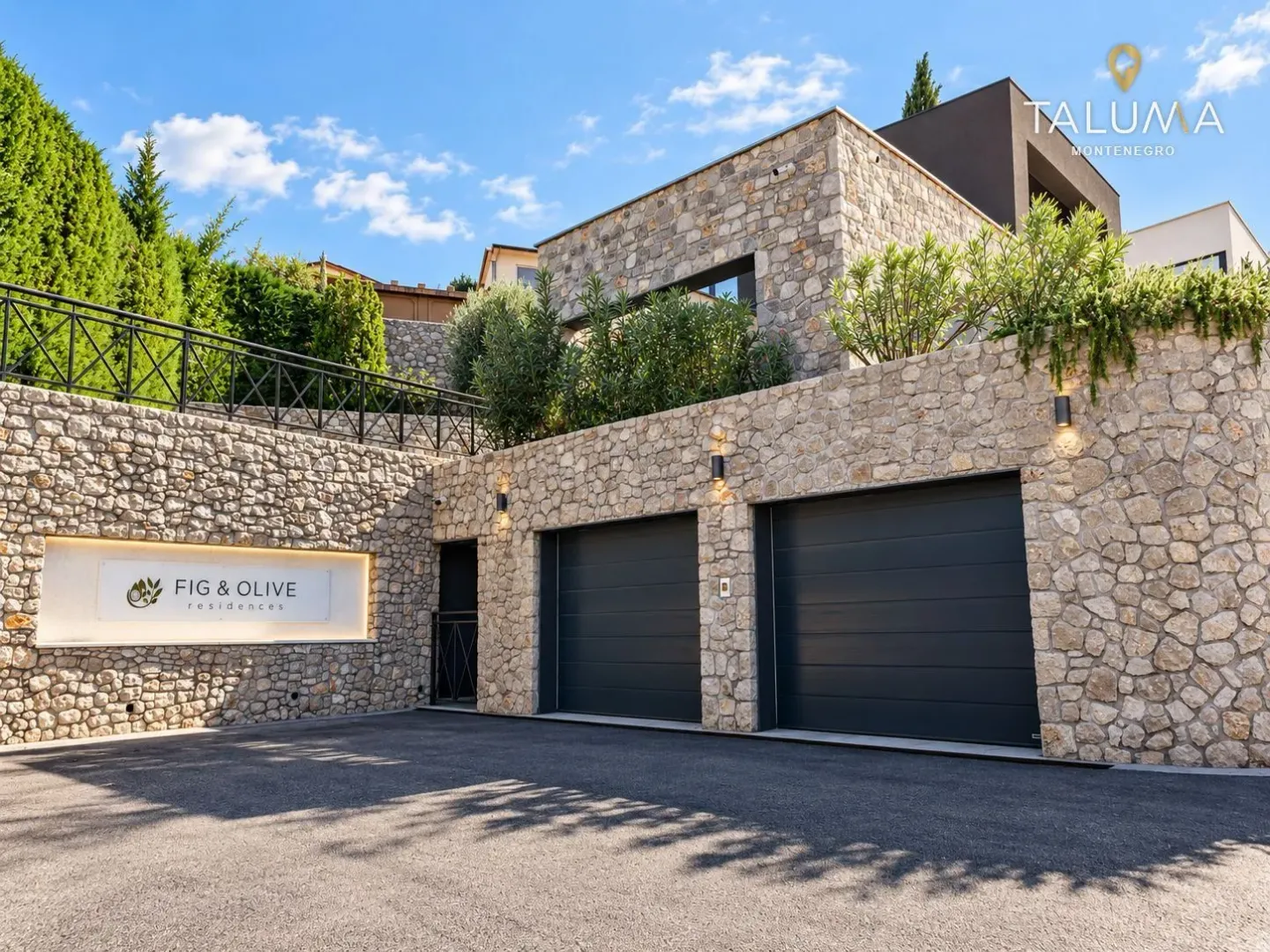 View of the exterior of the house with a stone facade and garage doors.