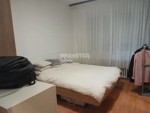 Nameštena spavaća soba sa bračnim krevetom i prozorom prekrivenim zavesama. - image 5